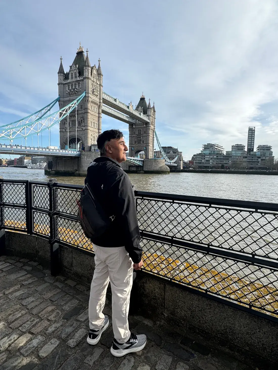 Neo looking across the river beside Tower Bridge