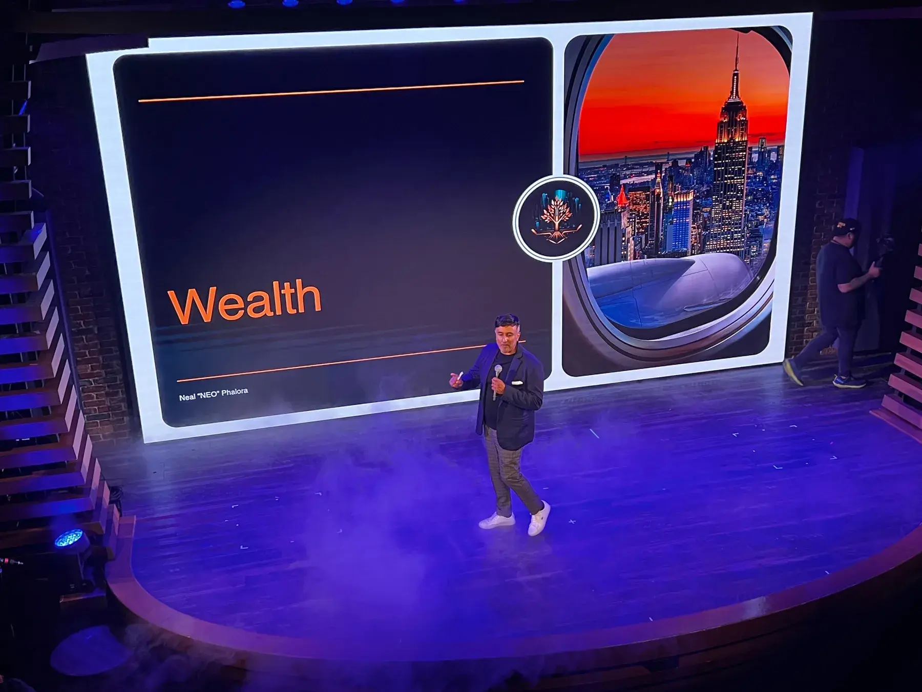 Neo speaking on a wide stage